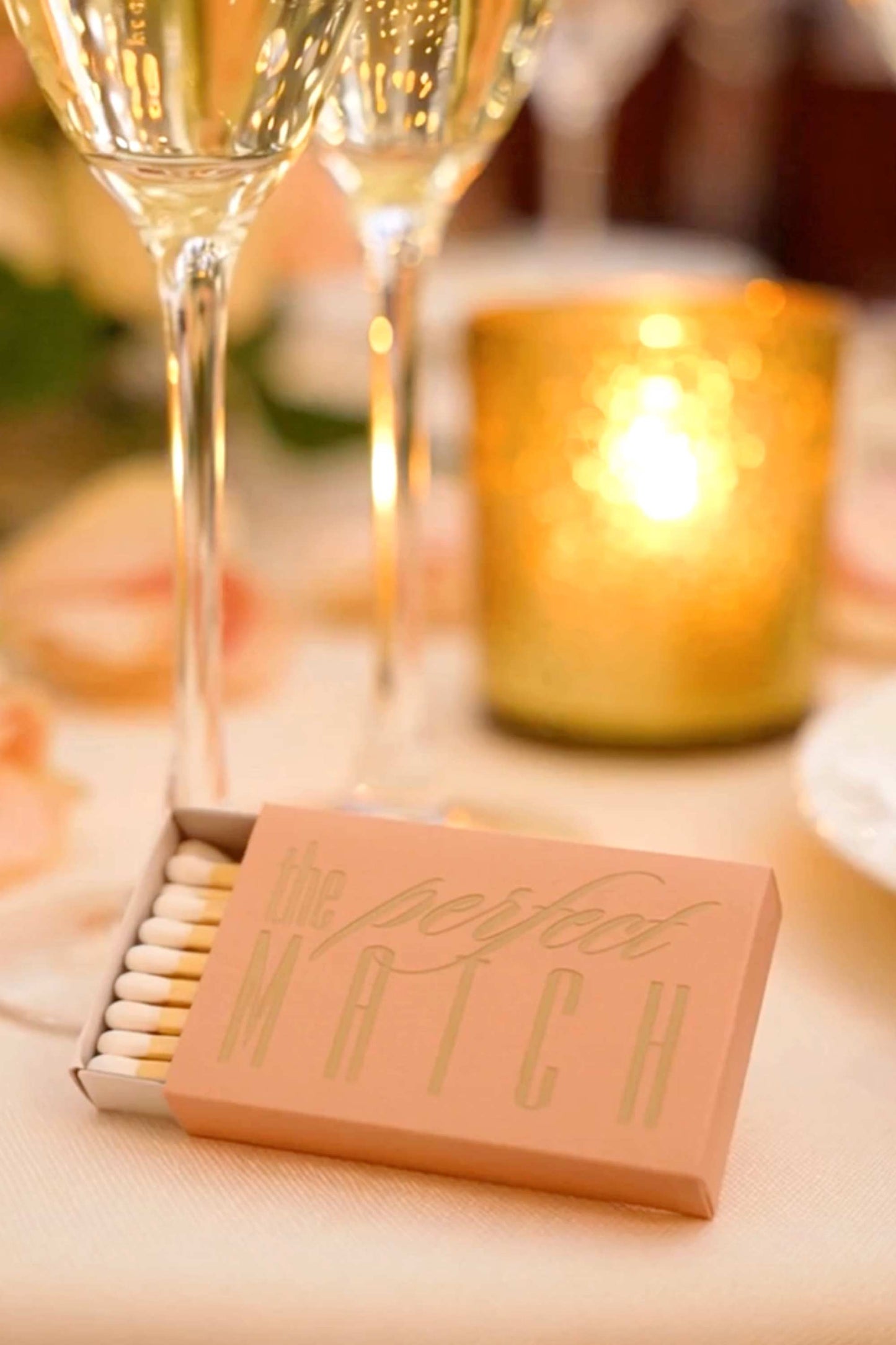 Matches box labeled 'The Perfect Match' with a glass of champagne and candle in the background