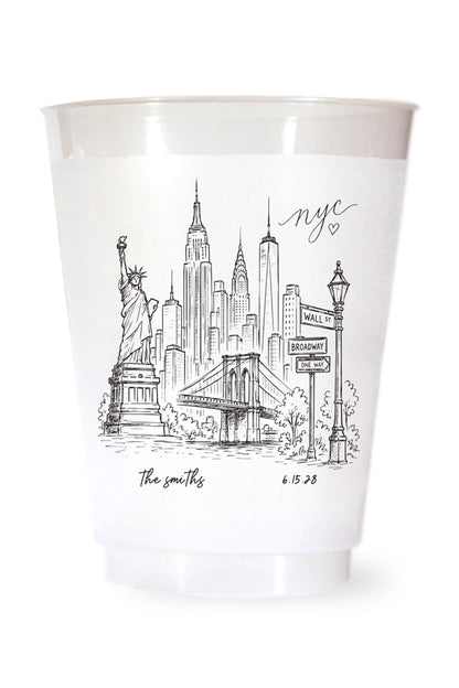 white shatterproof plastic cup on a white background. the cup is printed with a hand drawn illustration of the new york city sklyine with the bride and grooms names and wedding date in black ink.