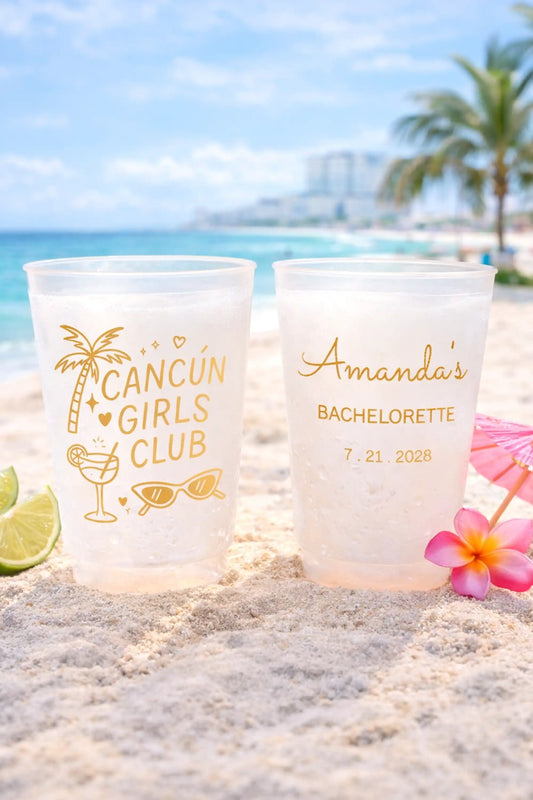 Two personalized cups on a beach with palm trees and ocean in the background.