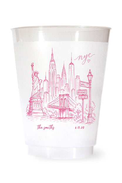 white shatterproof plastic cup on a white background. the cup is printed with a hand drawn illustration of the new york city sklyine with the bride and grooms names and wedding date in hot pink ink.
