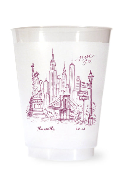 white shatterproof plastic cup on a white background. the cup is printed with a hand drawn illustration of the new york city sklyine with the bride and grooms names and wedding date in burgundy ink.