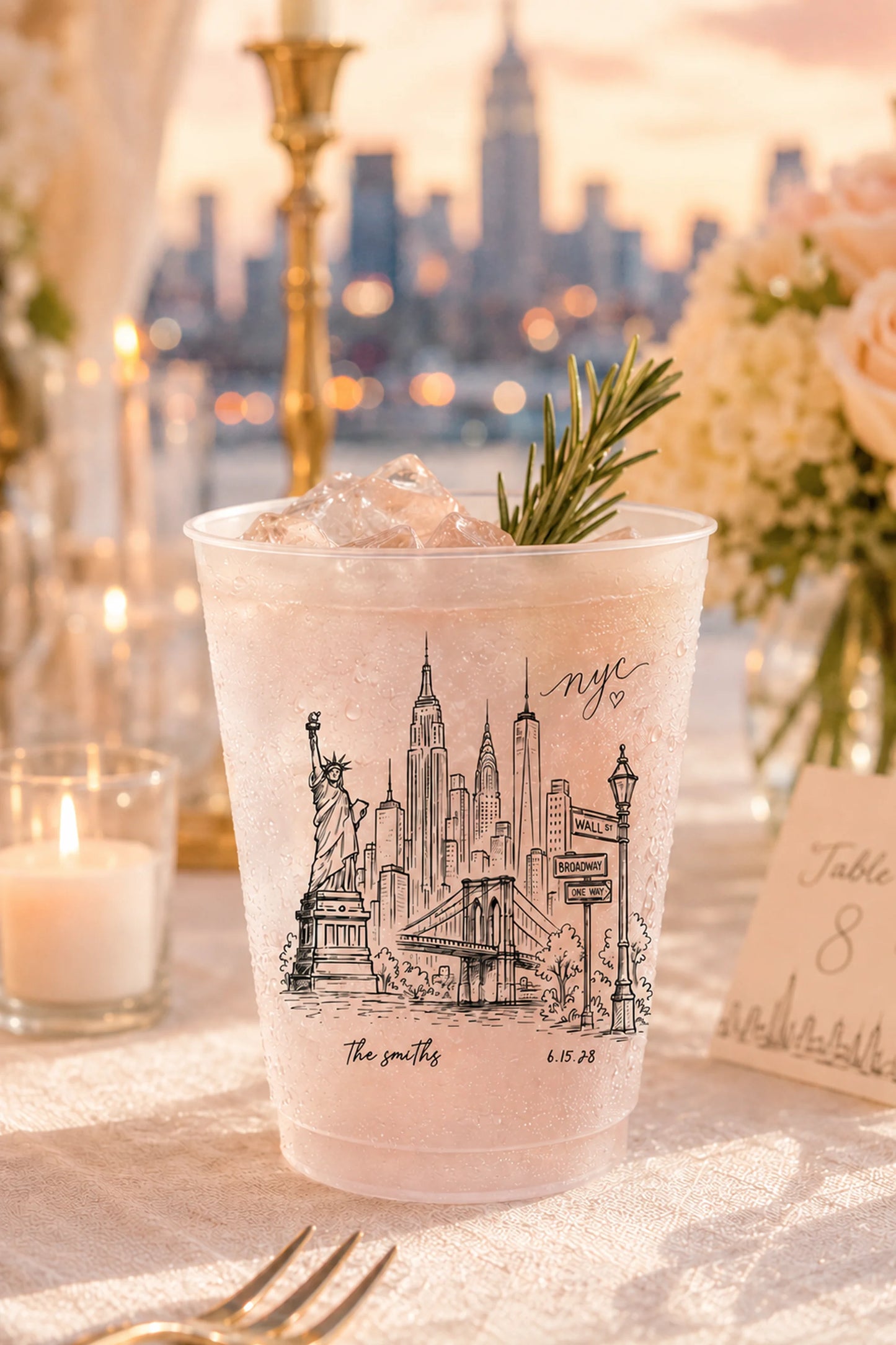 white shatterproof plastic cups with the new york city skyline printed on it in black ink with the bride and grooms name and wedding date on a table overlooking new york city skyline.