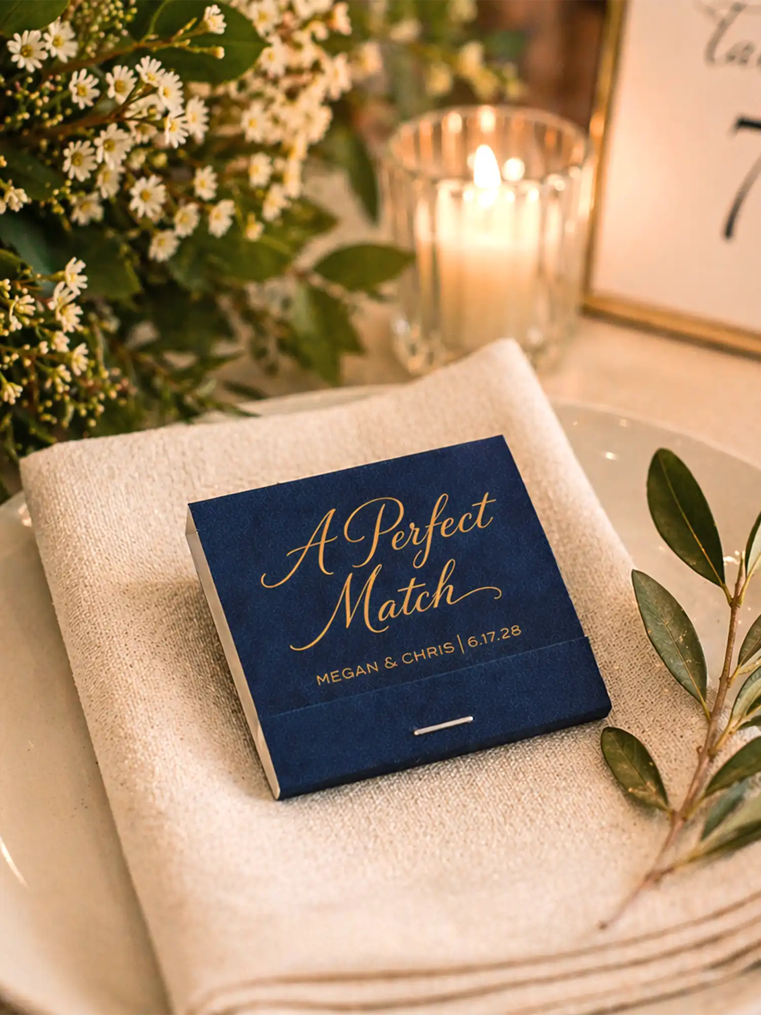 Wedding card box labeled 'A Perfect Match' on a table with flowers and candles.