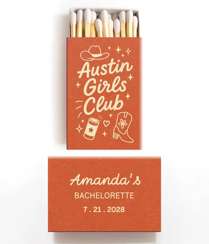 Orange and ivory matchbox with 'Austin Girls Club' design and 'Amanda's Bachelorette' text on a white background