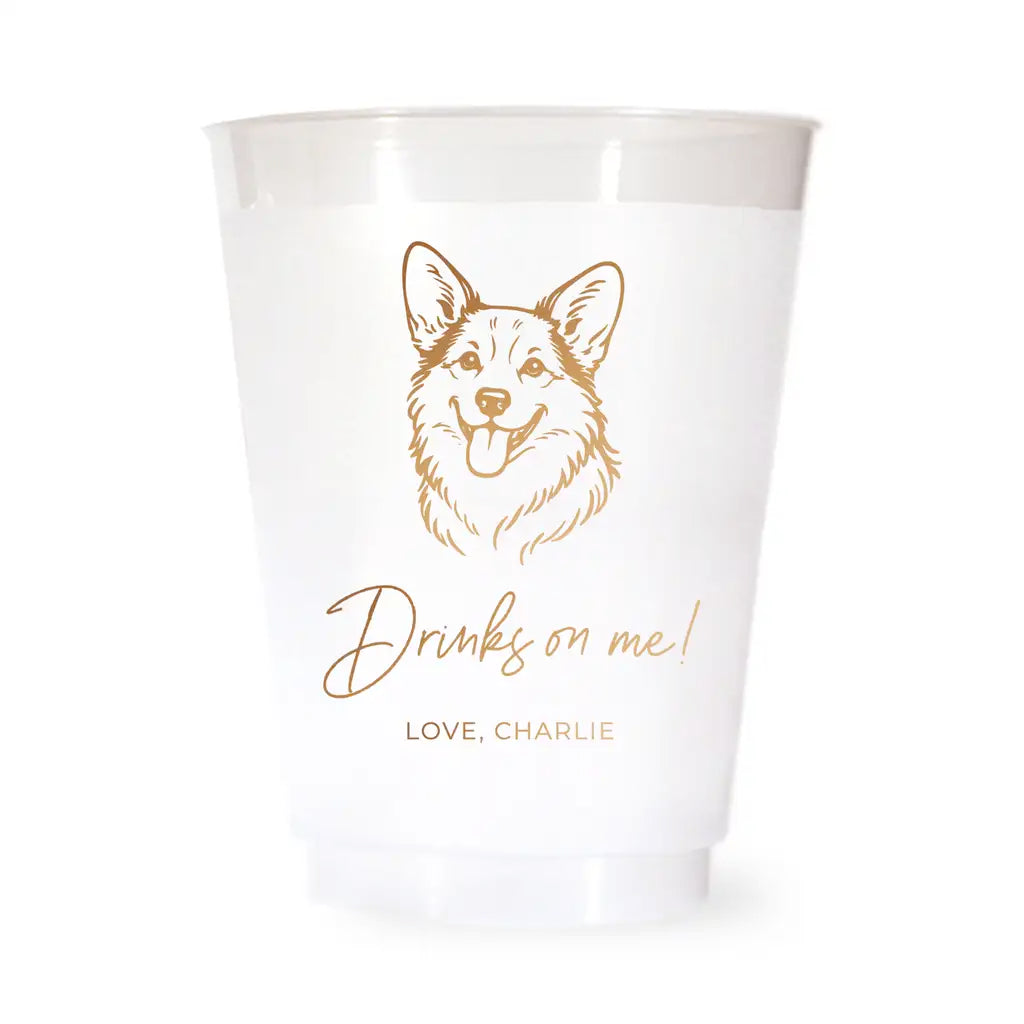 White cup with a corgi dog illustration and text 'Drinks on me! Love, Charlie' on a white background