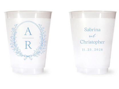 Two white cups with blue monogram and text on a white background