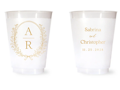 Two white cups with gold monogram and personalized text on a white background