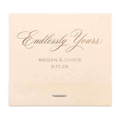 Beige matchbook with 'Endlessly Yours' and rose gold personalized names and date on a white background