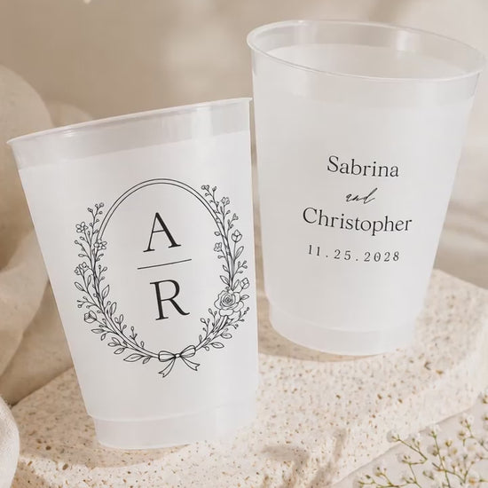 2 wedding cups on a stone plate near white flowers