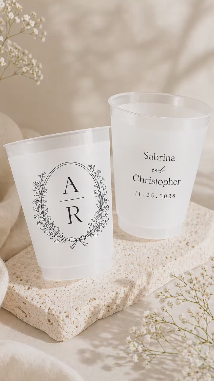 2 wedding cups on a stone plate near white flowers