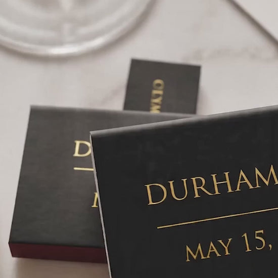 black and gold wedding matchboxes favors on a marble wedding table