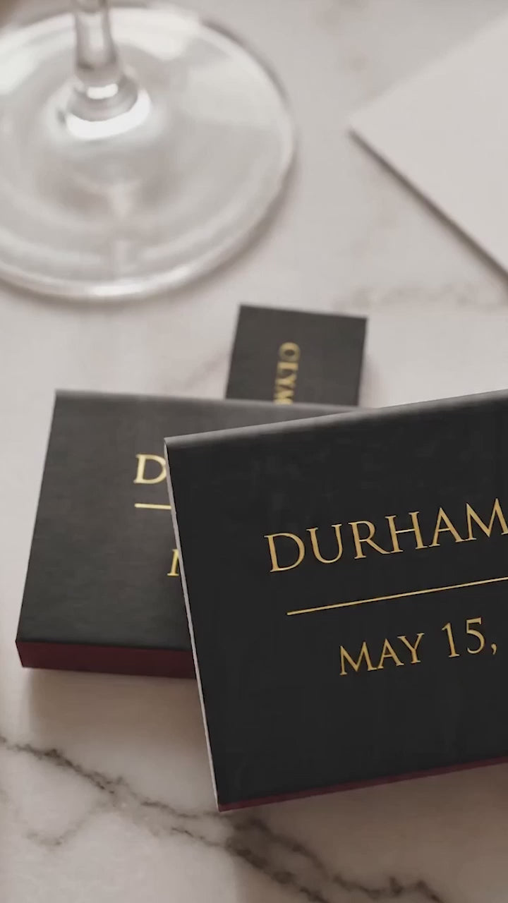 black and gold wedding matchboxes favors on a marble wedding table