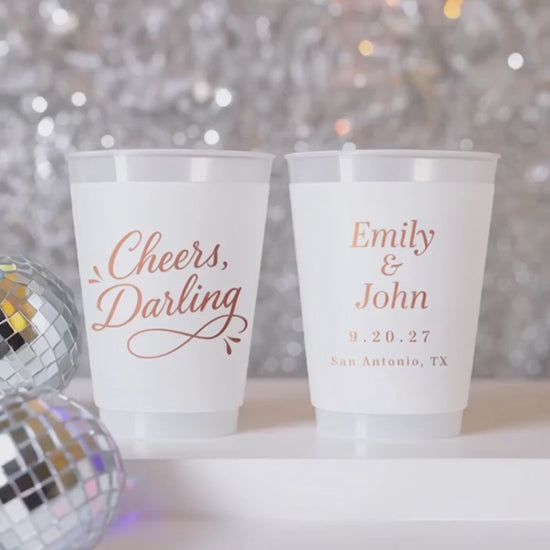 cheers darling personalized wedding cups on a white table with silver decor and disco balls.