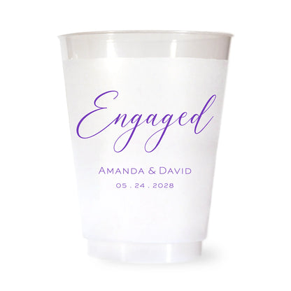 Clear plastic cup with purple 'Engaged' text and personalized names and date on a white background